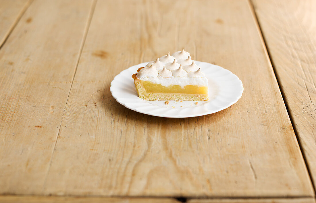 A piece of lemon meringue pie (lemon cake with meringue, USA)