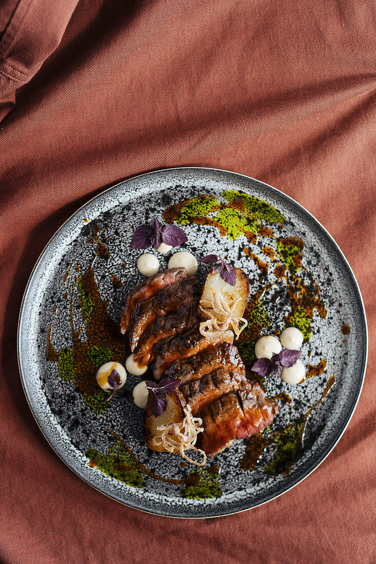 Sliced beef steak served on a ceramic plate