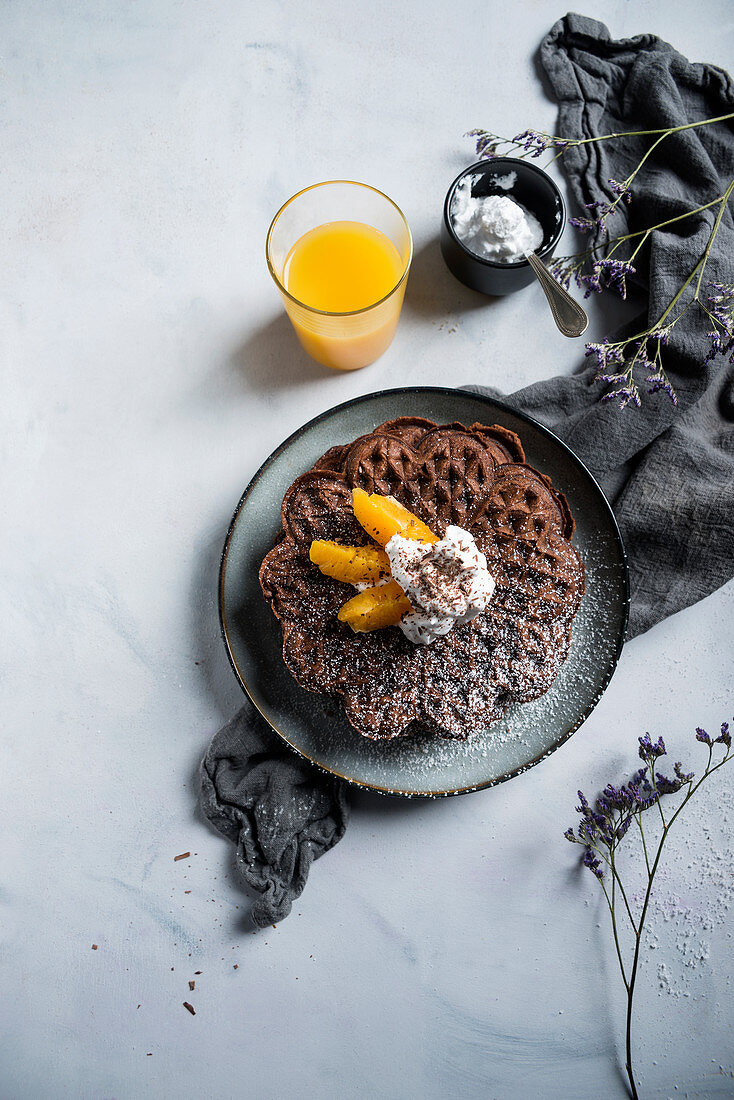Vegan chocolate waffles with orange fillets, soy butter cream and grated chocolate