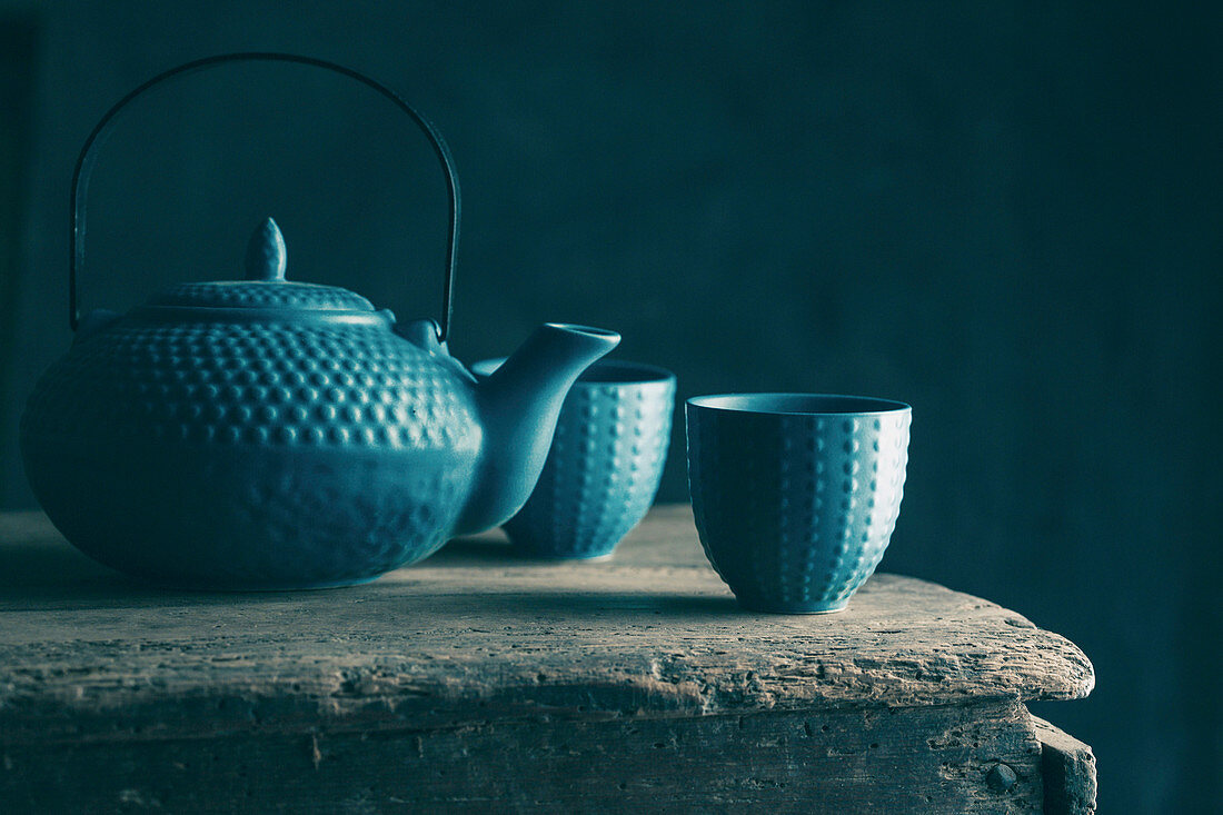 Teapot and cup of tea on wooden background