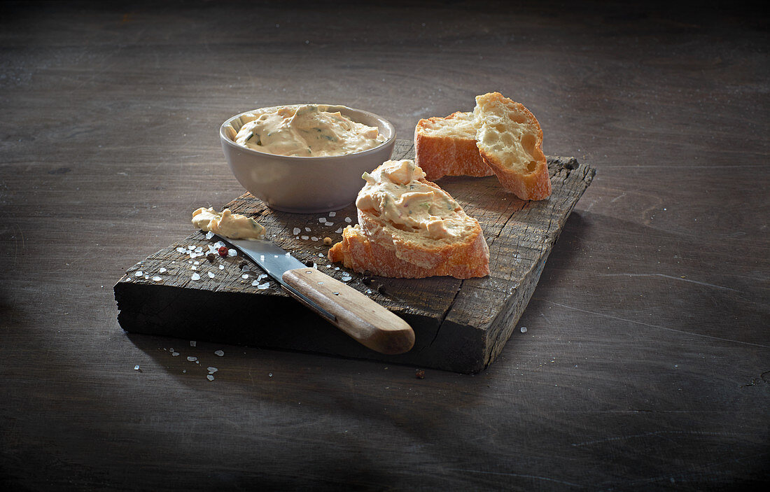 Chive cream cheese cream in a bowl and on baguette slices