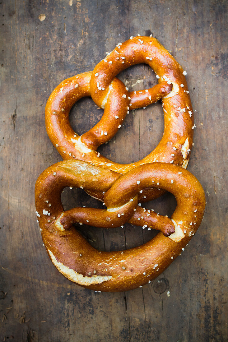Two pretzels on a wooden background (top view)