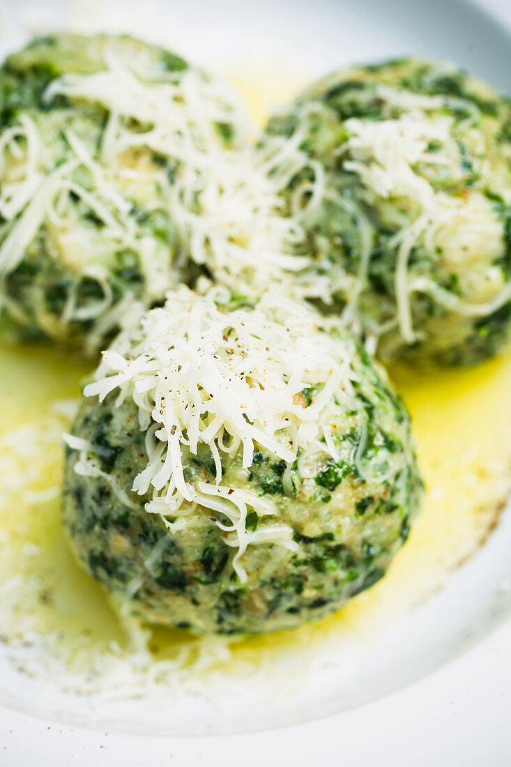 Spinach dumplings with butter and grated cheese (close up)