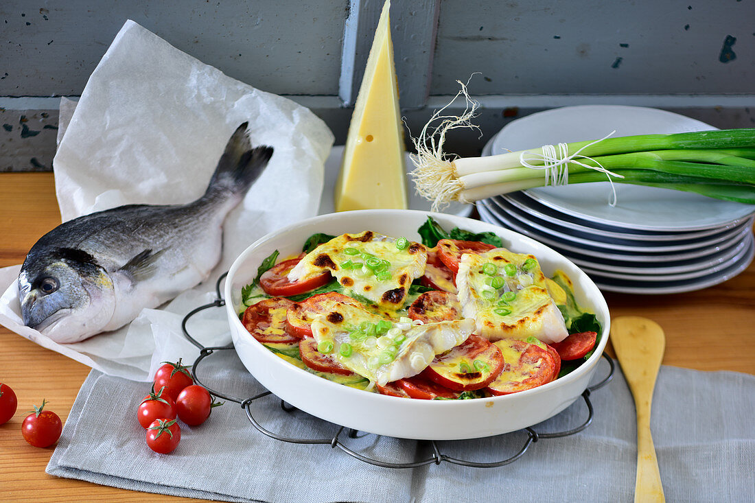 Cheese topped fish fillets with tomatoes and spinach