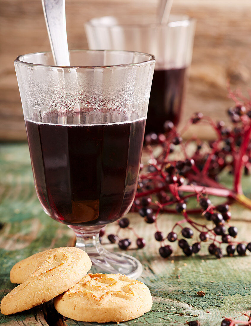 Elderberry mulled wine and cookies on a wooden surface