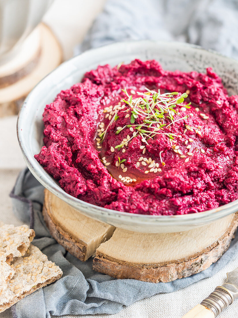 Roasted beetroot white bean hummus decorated with sprouts (vegan)