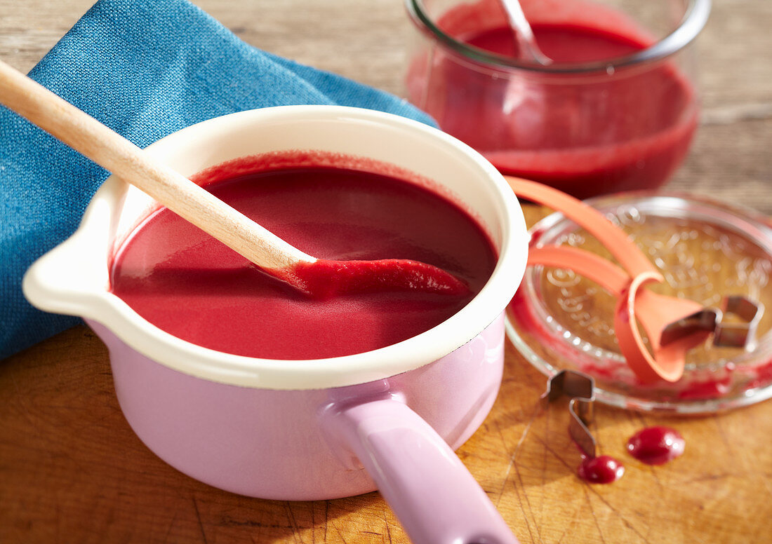 Beetroot soup with horseradish and apple in a saucepan and a jar