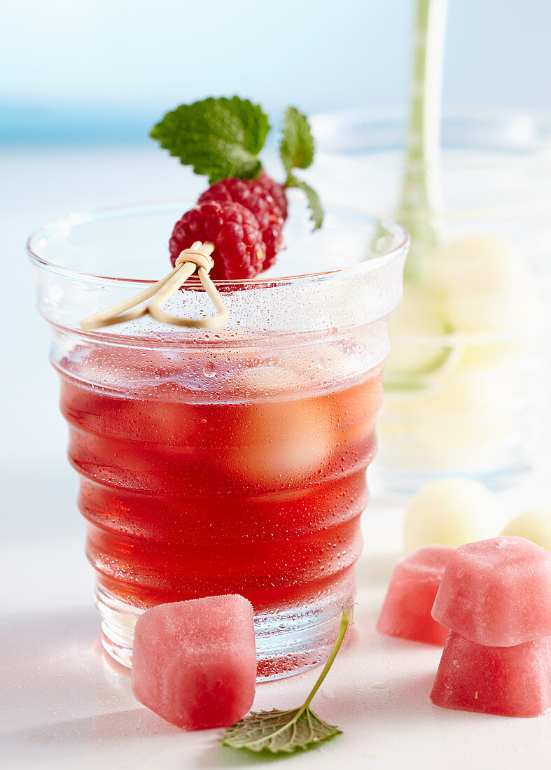 Non-alcoholic punch with raspberries and honey dew melon served with pink ice cubes