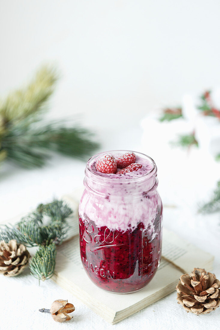 Berry jam in a glass jar with yoghurt