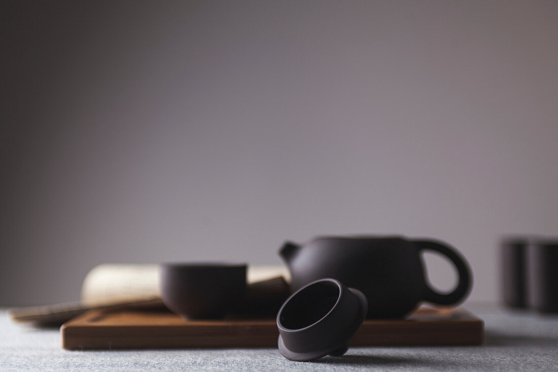 Oriental teapots and tea bowls on a wooden board