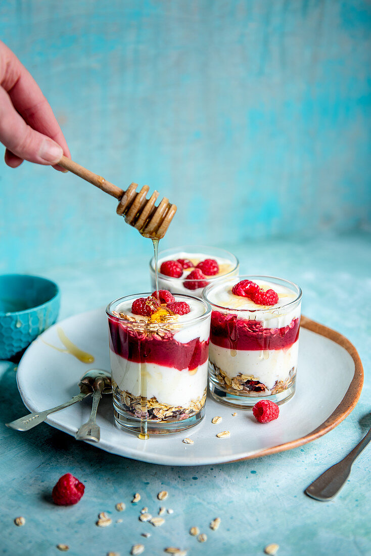Yoghurt, granola and raspberry pots with honey