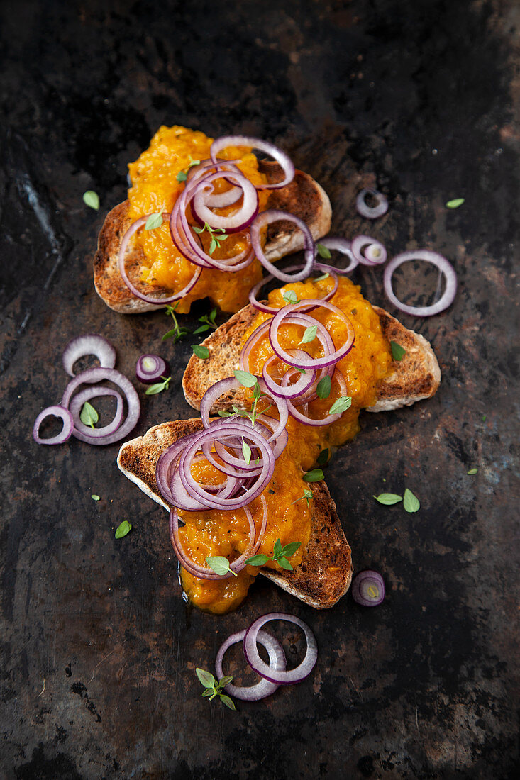 Yellow pepper spread on toast with red onions