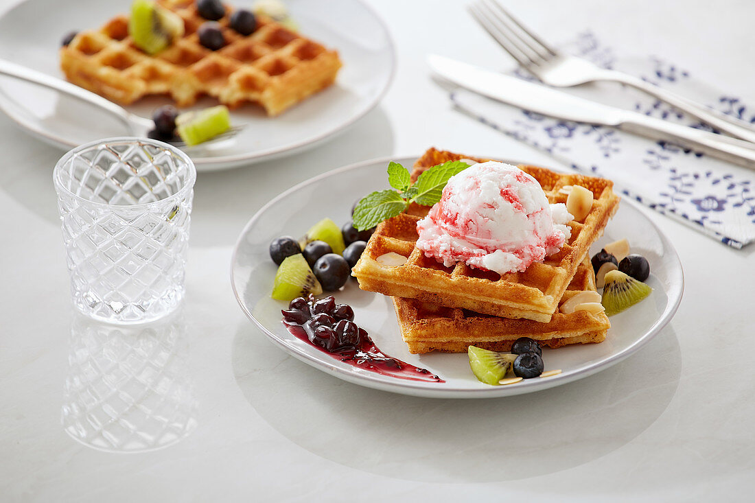 Waffeln mit Blaubeeren, Kiwi, schwarzer Johannisbeermarmelade und Eiskugel