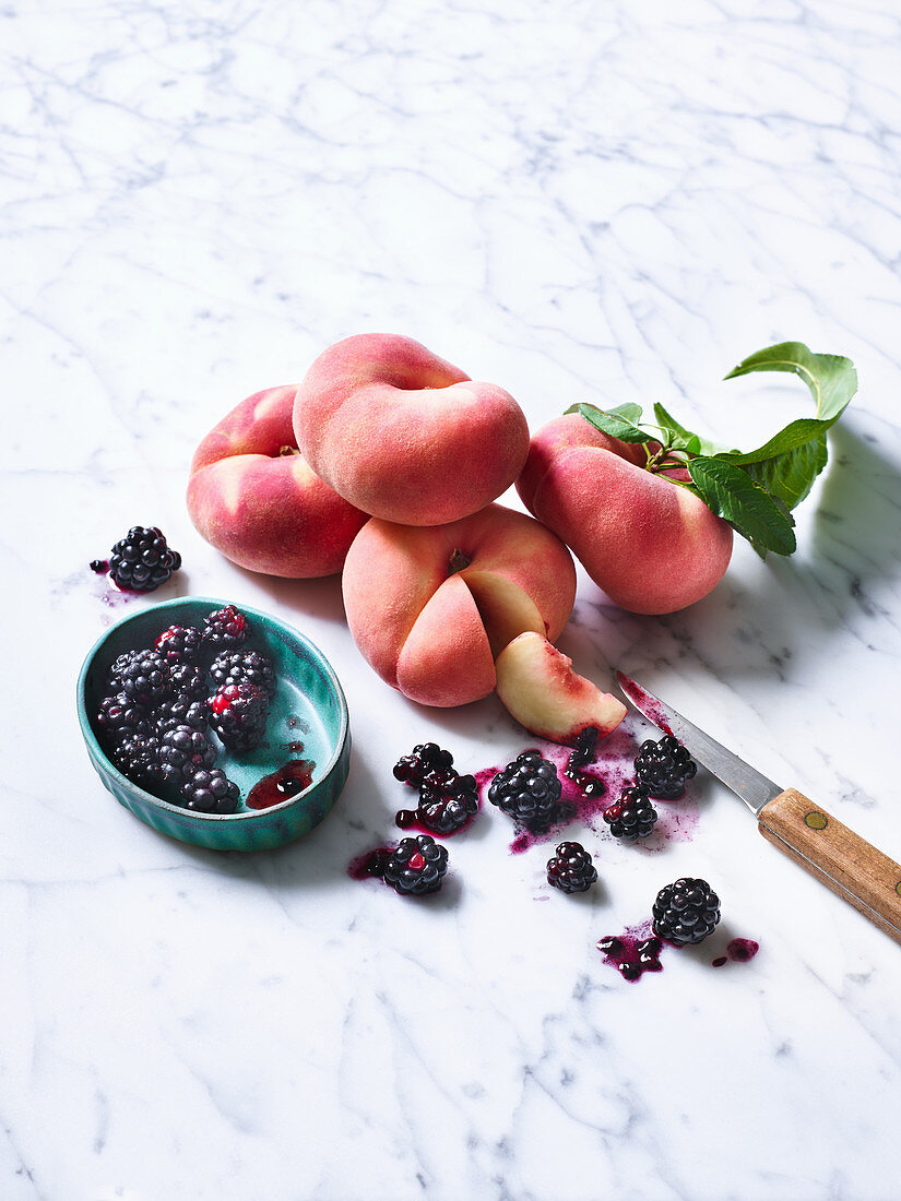 Weinbergpfirsiche und Brombeeren auf Marmorplatte