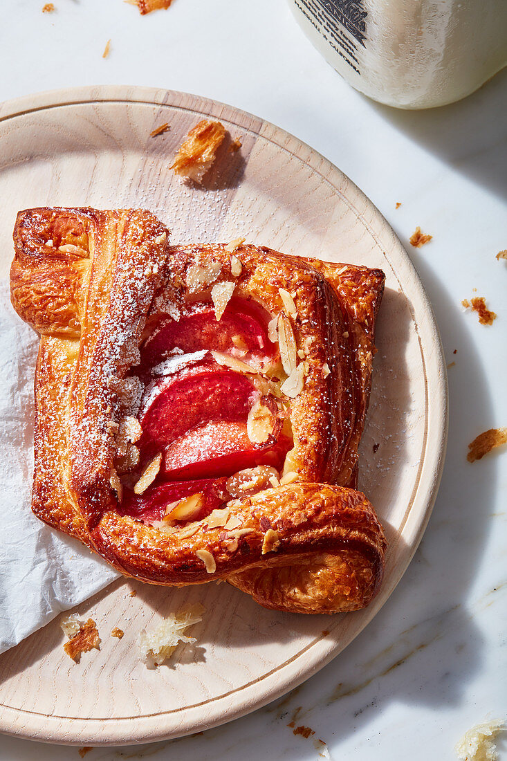 Danish pastry filled with fruit on a wooden plate