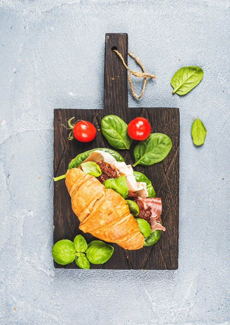 Croissant sandwich with Prosciutto di Parma, sun dried tomatoes, fresh spinach and basil