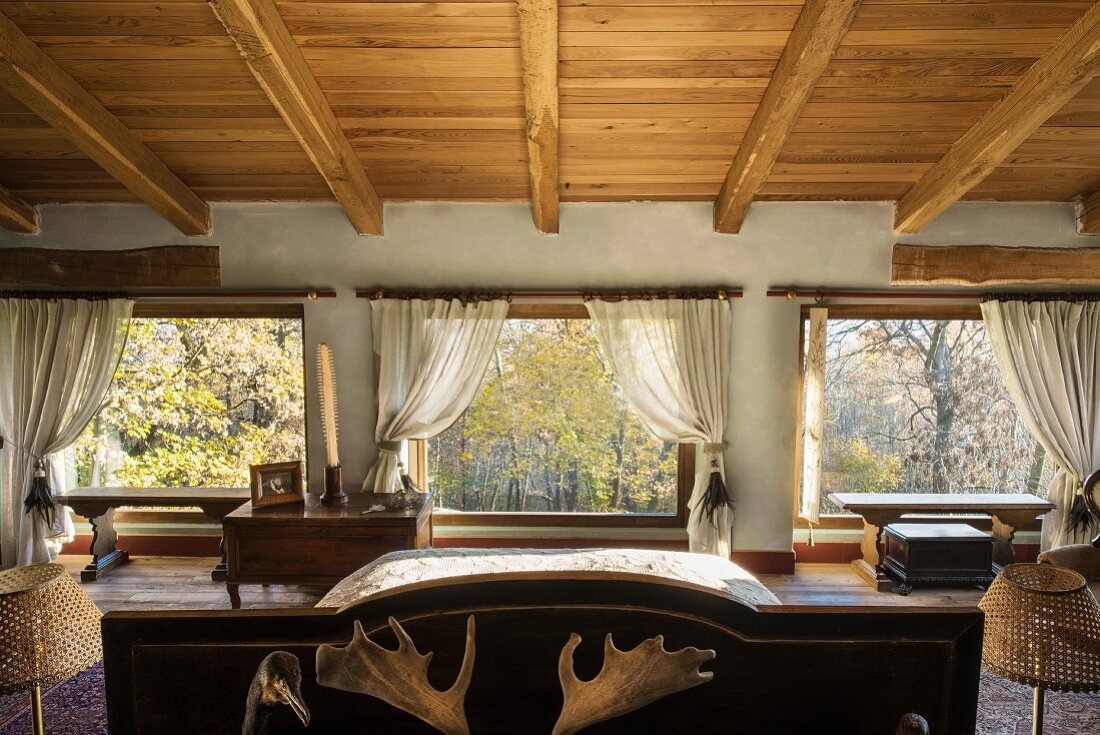 Dachgeschossschlafzimmer im Landhausstil mit Fensterfront und Waldblick
