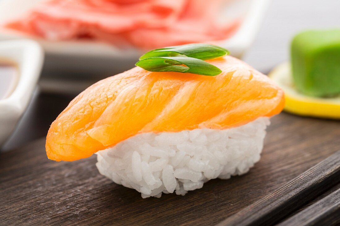 Nigiri sushi with salmon on a wooden plate