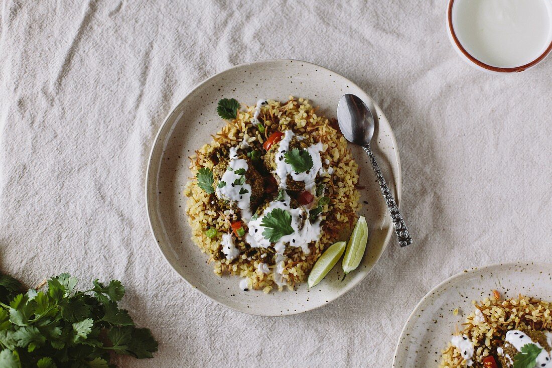 Curried Lentil Meatballs served on bulgur pilaf and topped with yogurt sauce
