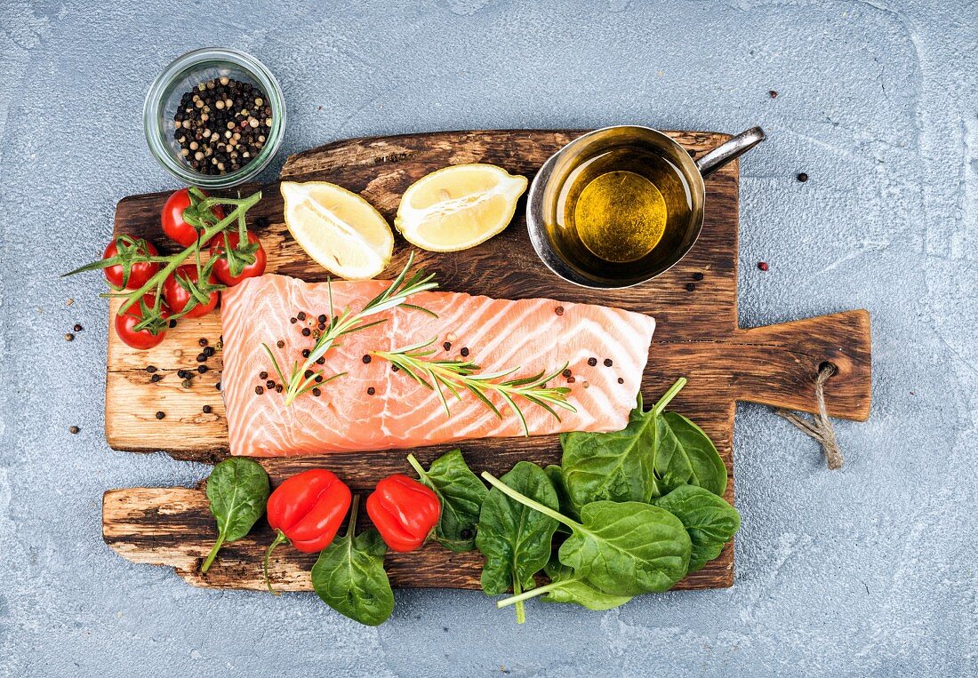 Zutaten für gesundes Abendessen: Lachsfilet, Spinat, Tomaten und Chilischote