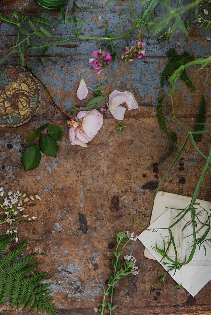 Various flowers and leaves on worn tabletop