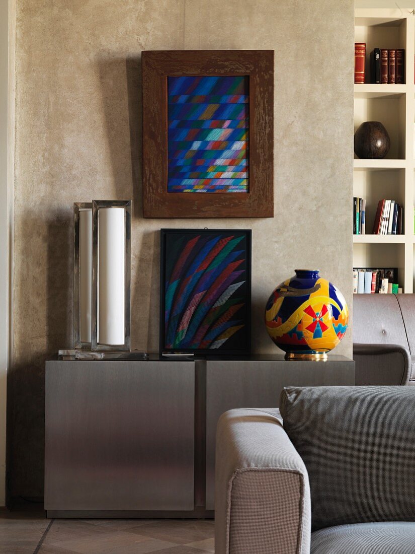 Modern artwork on modern sideboard against colour-washed wall