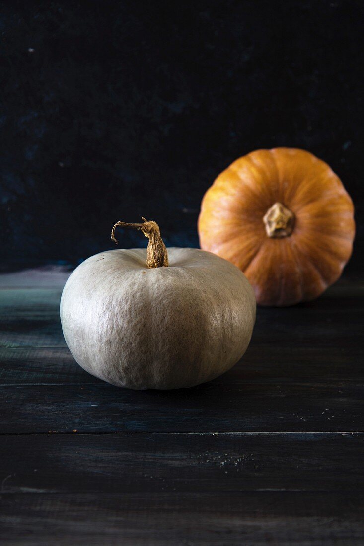 Two pumpkins on a wooden background