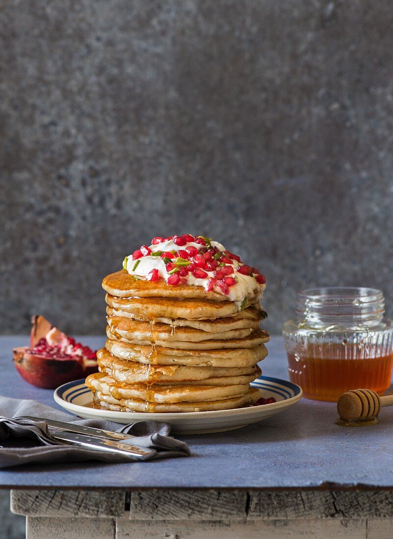 Wholemeal yoghurt pancakes with pomegranate seeds, yoghurt and honey