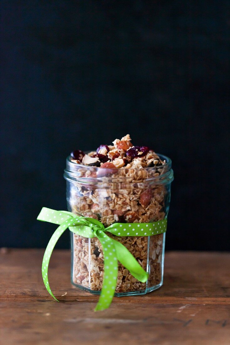 Almonds and cranberries homemade granola in a glass jar