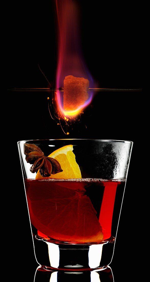 A burning sugar cube over a glass of Feuerzangenbowle
