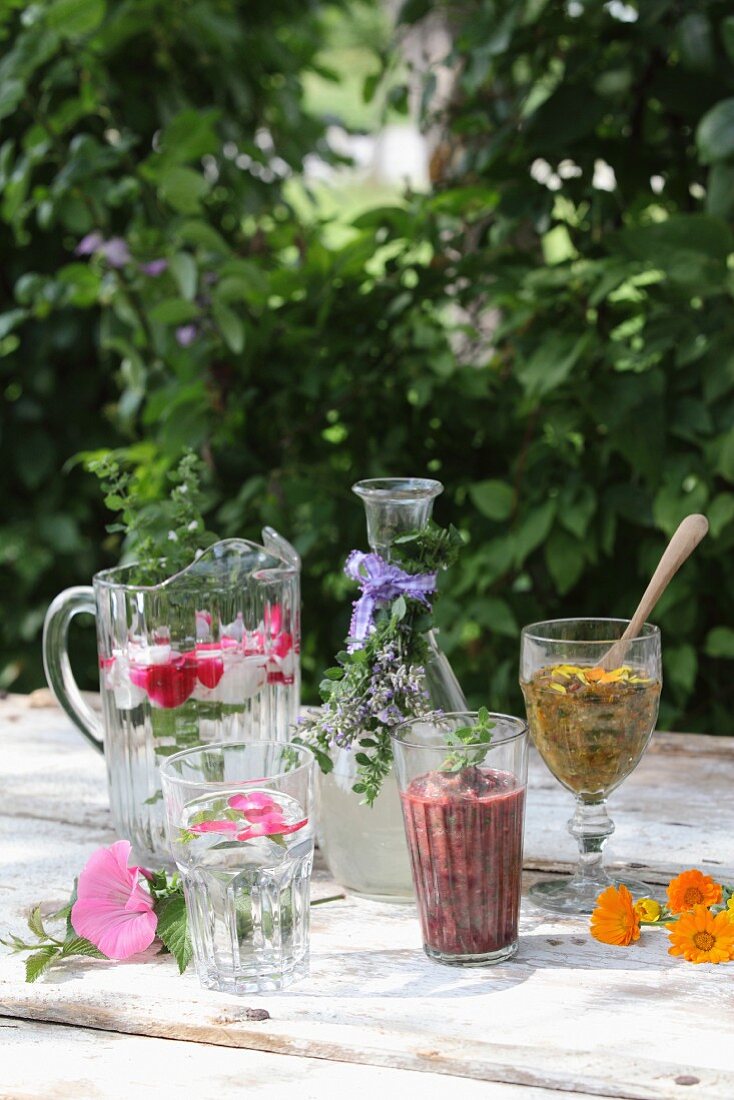Various herbal drinks on a garden table