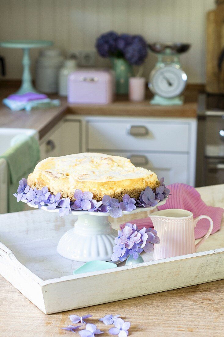 Cheesecake decorated with hydrangeas on a wooden tray