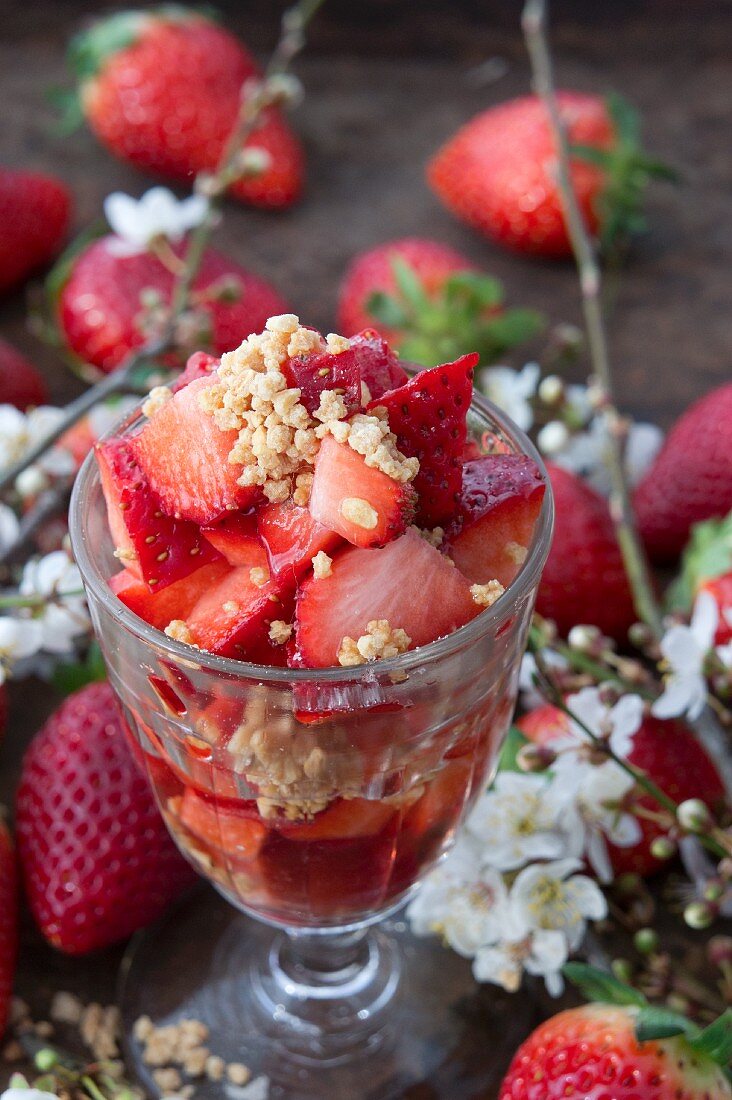 Erdbeeren mit Zucker und Krokant zwischen Erdbeeren und Schlehenblüten