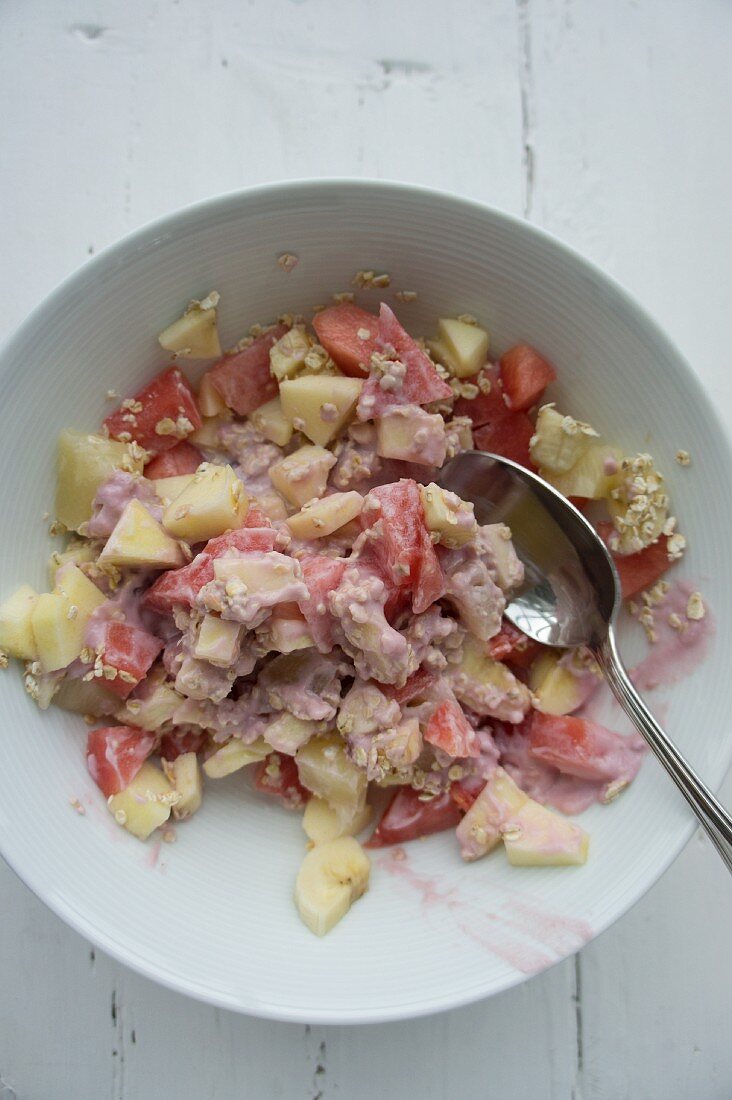 Muesli with oatmeal, melons, apples and yoghurt made from coconut milk