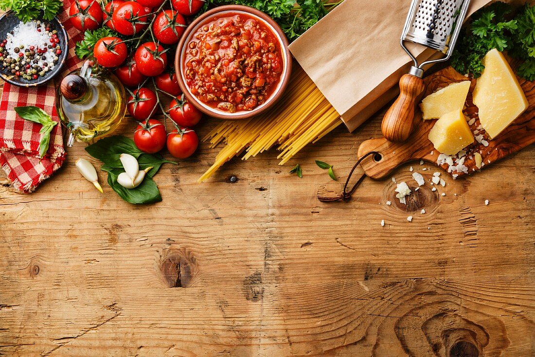 Zutaten für Spaghetti Bolognese: Tomaten, Hackfleischsauce, Spaghetti und Parmesan