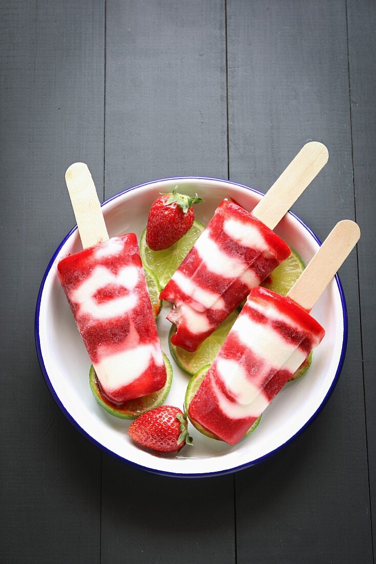 Erdbeer-Joghurt-Eis am Stiel auf einem Teller