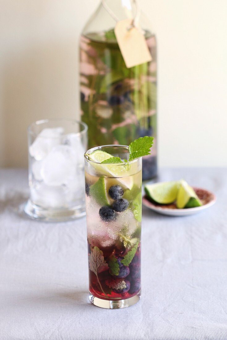 Ein Glas mit Heidelbeeren aromatisiertes Wasser mit frischer Minze und Limette