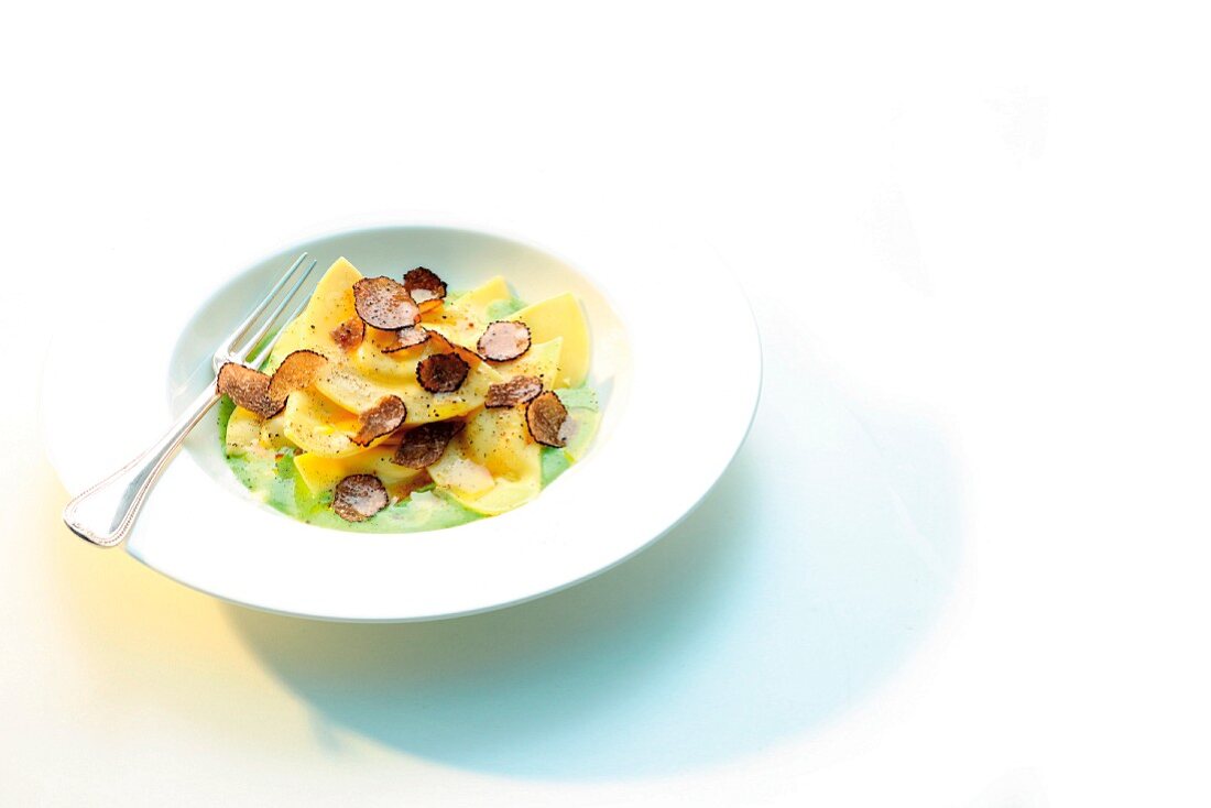 Swabian ravioli with celery on a creamy leek sauce with black truffle