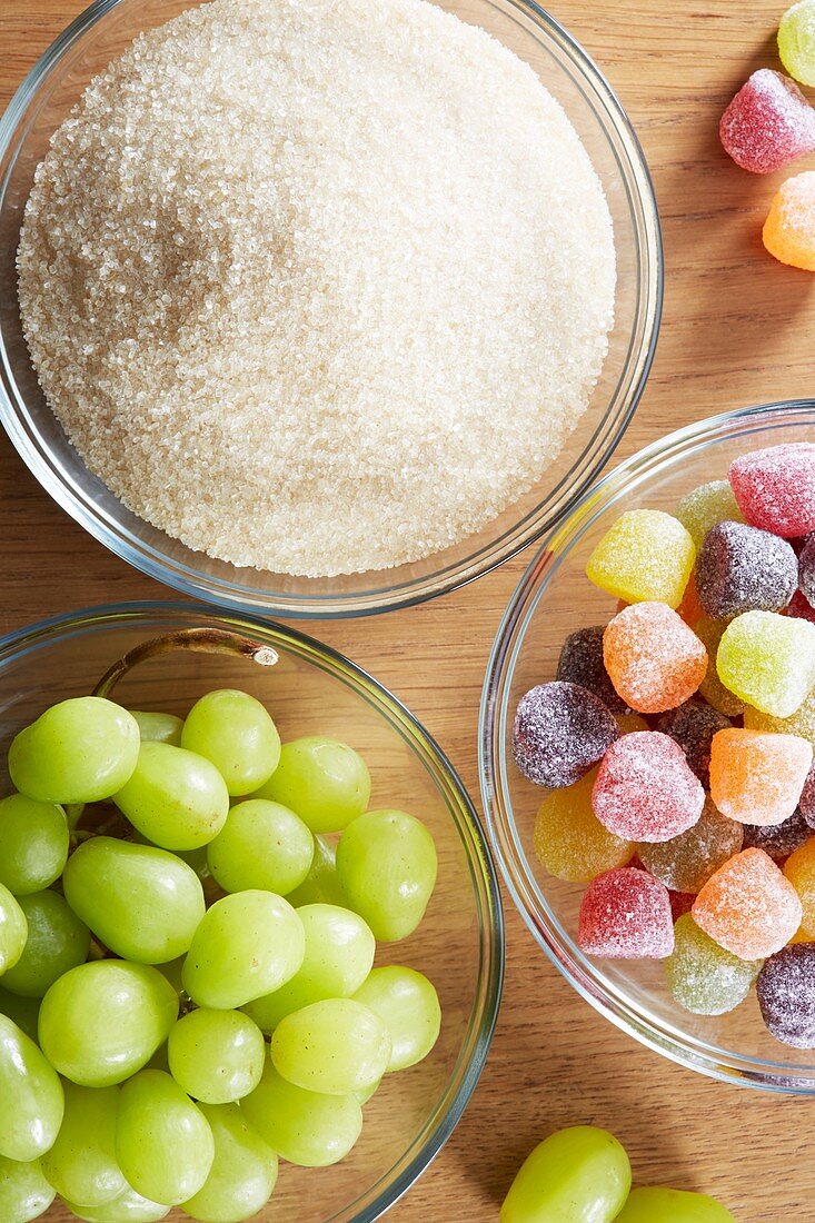 Bowls with sweets, grapes and sugar
