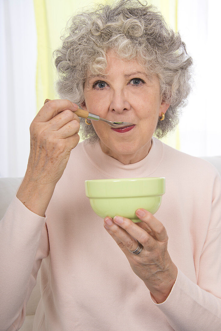 Woman eating from a bowl with a spoon