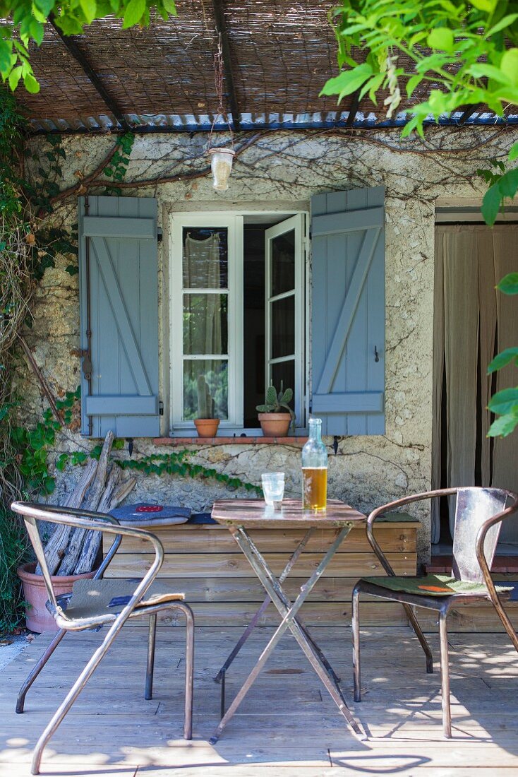 Vintage metal chairs and folding table on rustic terrace