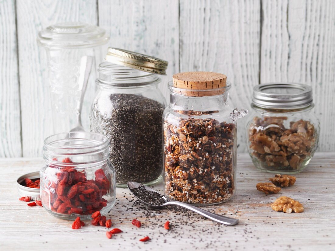 Storage jars of chia seeds, muesli, goji berries and walnuts