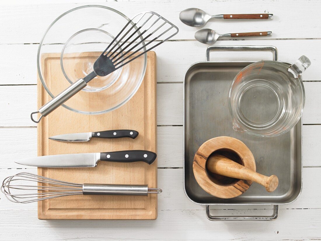 Various kitchen utensils: mortar, knives, measuring cup, glass bowl