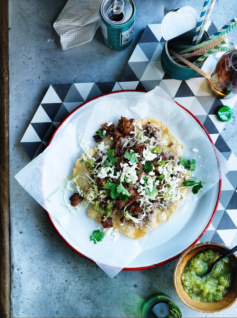 Oaxacan-style tlayudas tortillas with orn chips, pork belly and refried beans