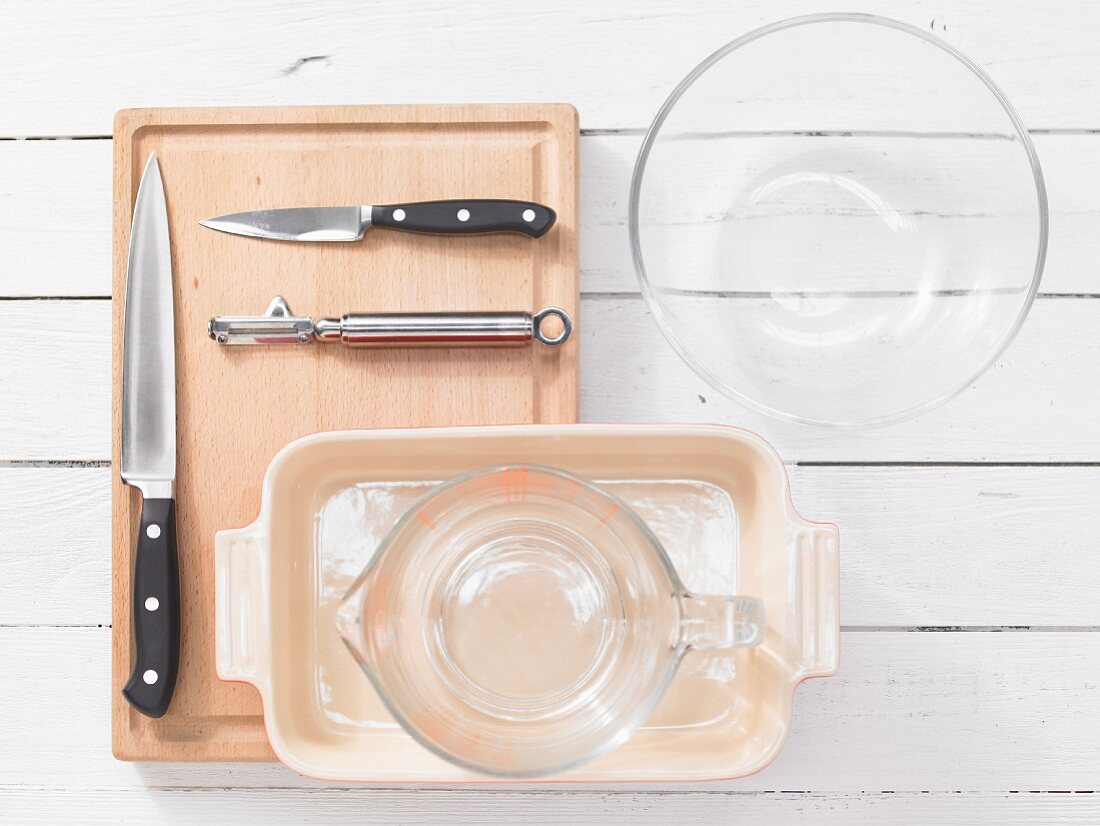 Various kitchen utensils: glass dishes, measuring jugs, casserole dish, knives, peeler