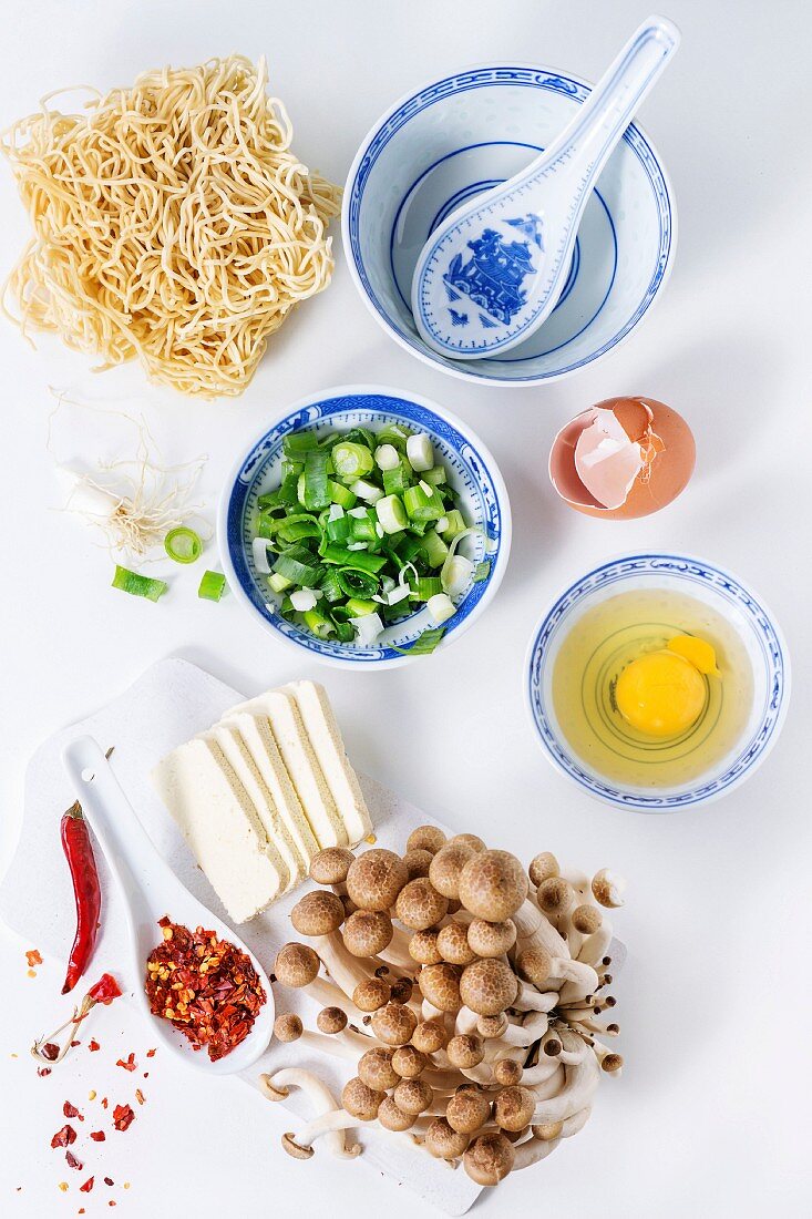 Zutaten für Ramen-Suppe mit Frühlingszwiebeln, Käse, Pilzen, Ei und Chili (Asien)