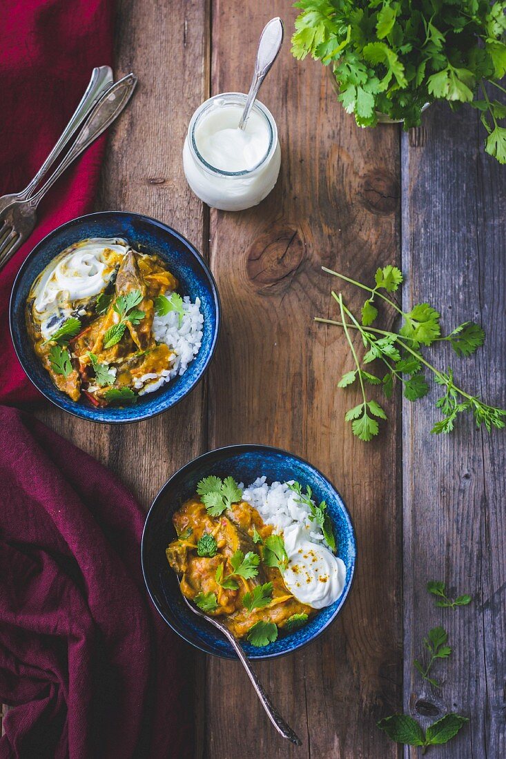 Aubergine curry with coriander and rice in bowls