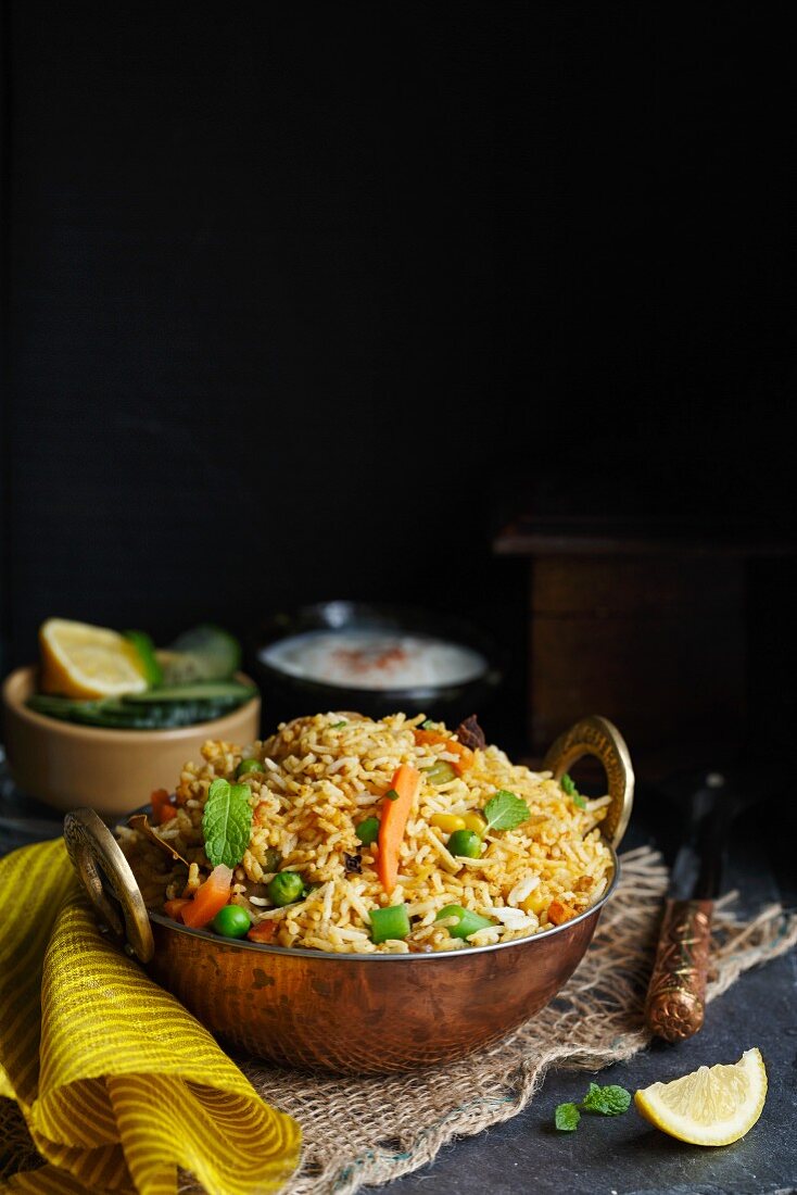 Gemüse-Biryani (Reisgericht, Asien) vor schwarzem Hintergrund
