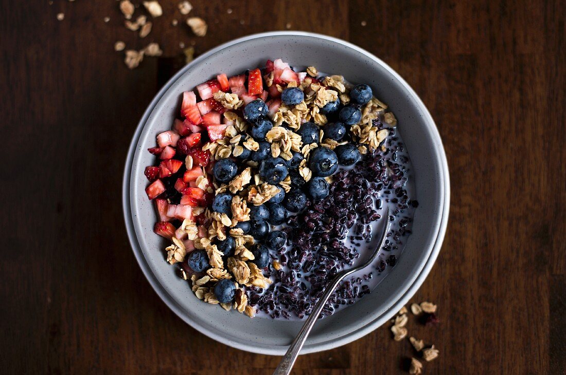 A bowl of Forbidden Rice Morning Cereal with Berries and granola