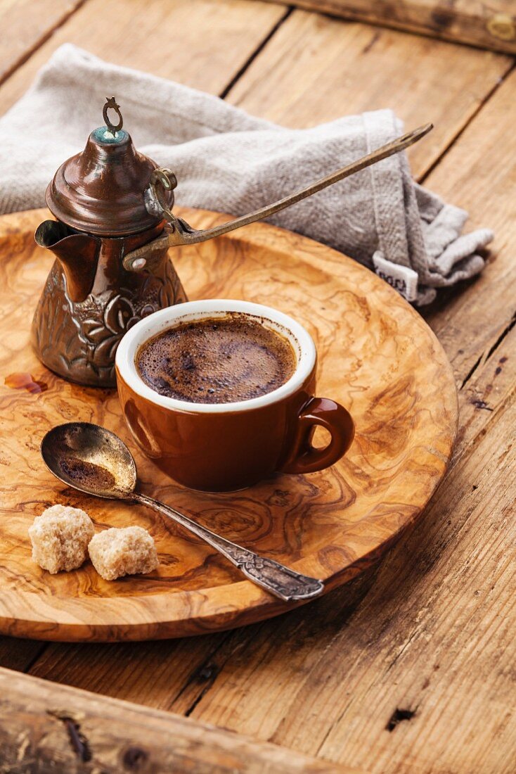 Cezve und Tasse türkischer schwarzer Kaffee auf Holztablett